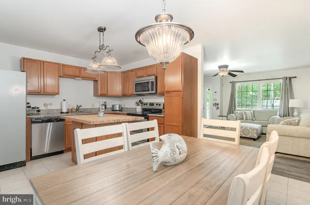 a large kitchen with granite countertop a white cabinets and stainless steel appliances