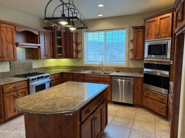 a kitchen with stainless steel appliances granite countertop a sink and a stove
