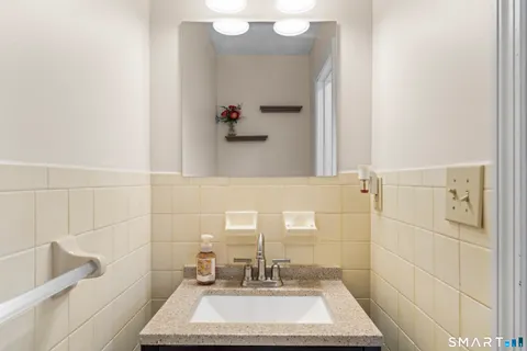 a bathroom with a sink a toilet and mirror