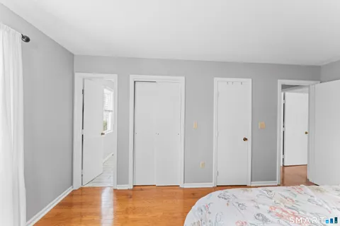 a bedroom with bed and wooden floor