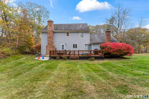 a backyard of a house with large trees and plants