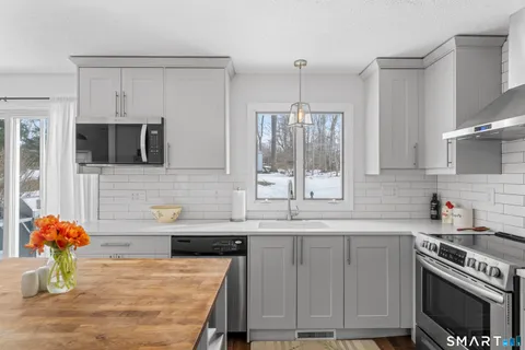 a kitchen with stainless steel appliances granite countertop a sink stove and cabinets