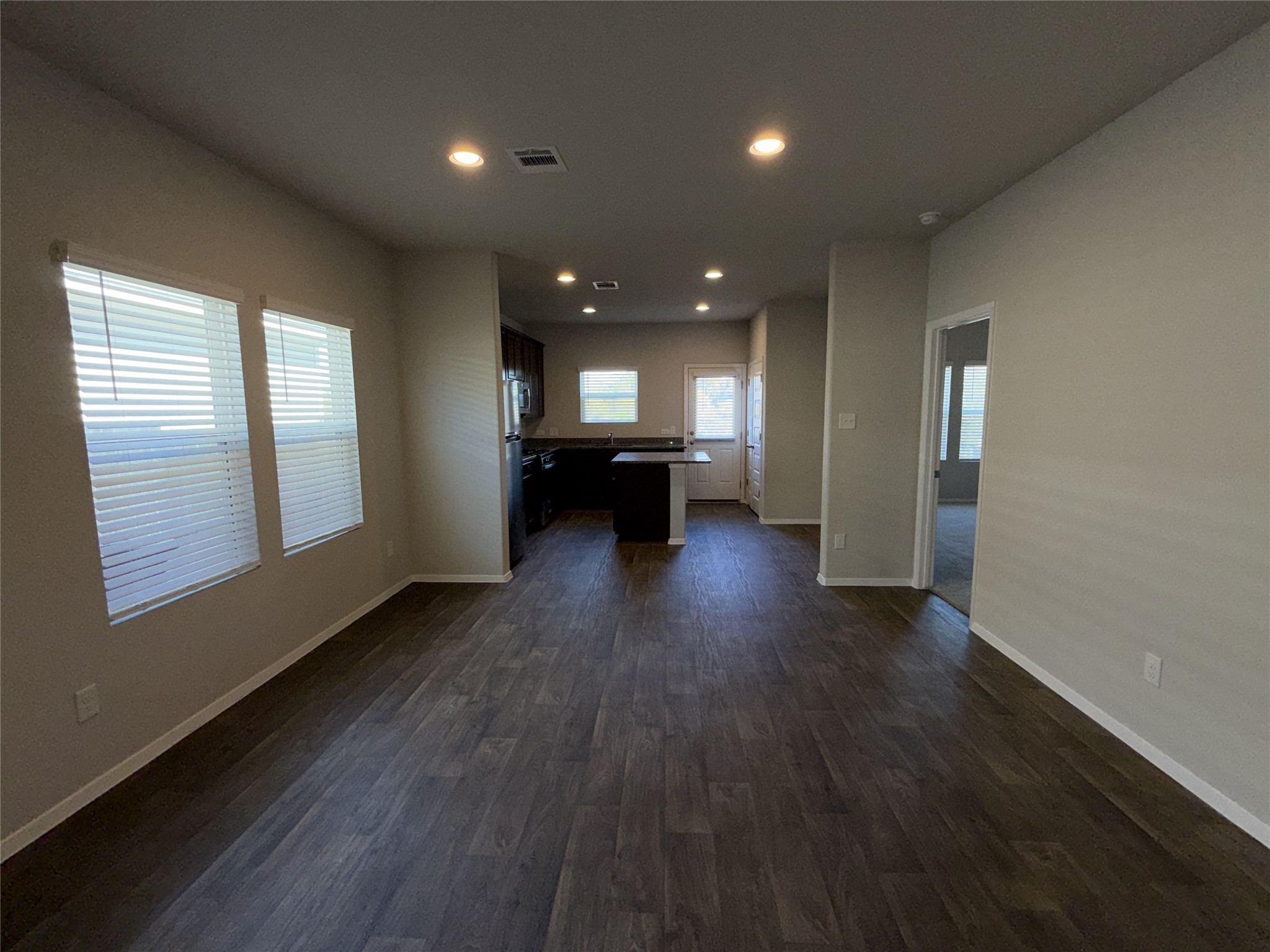 129 Tall Grass Drive Georgetown, TX 78628 - Photo 5 of 21 an empty room with wooden floor and a kitchen