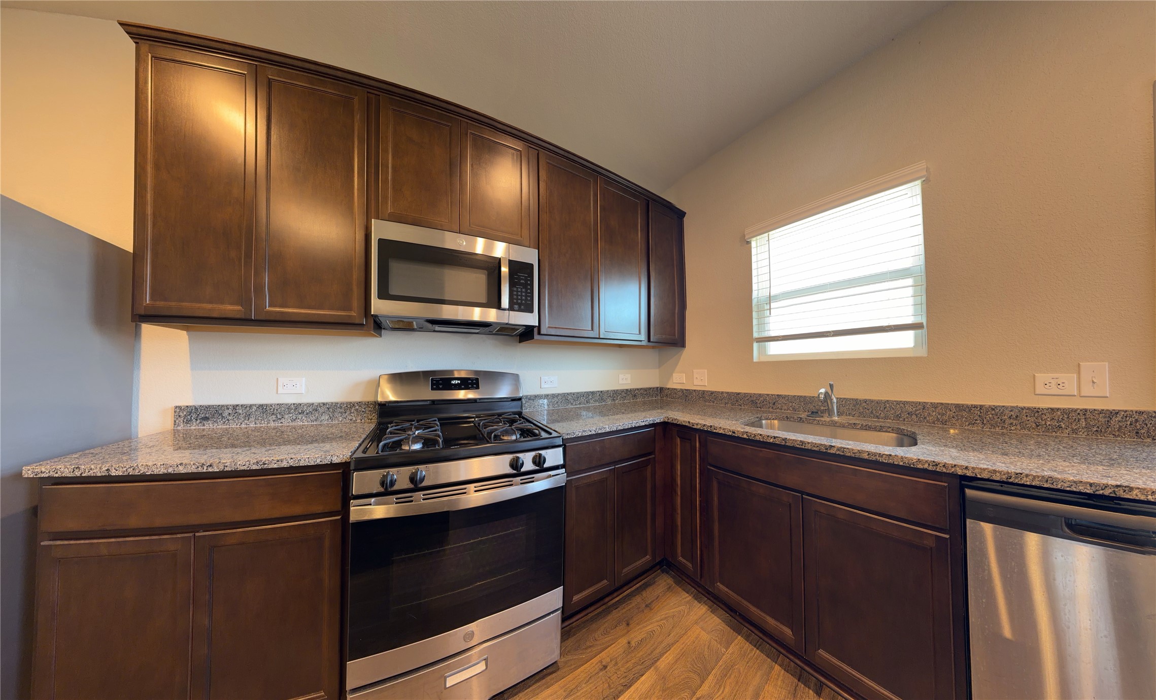 129 Tall Grass Drive Georgetown, TX 78628 - Photo 7 of 21 a kitchen with granite countertop a sink cabinets and stainless steel appliances