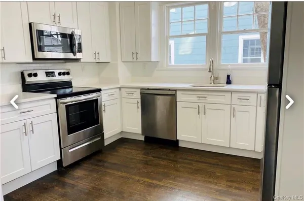 a kitchen with a sink a refrigerator and window