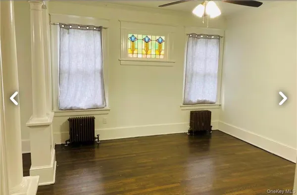 a view of a room with a window and wooden floor
