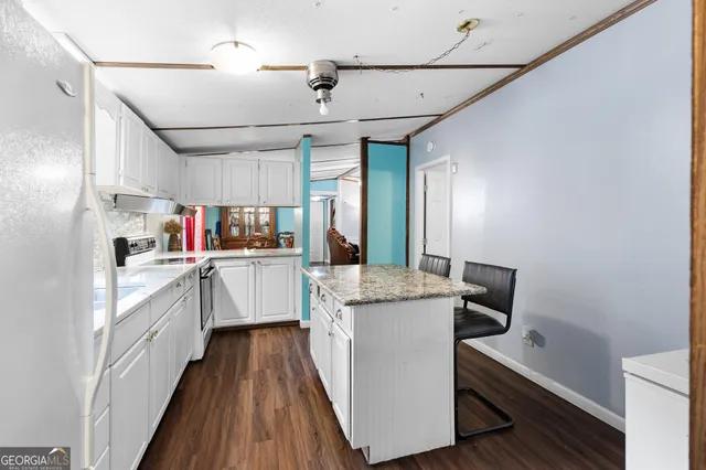 a kitchen with granite countertop cabinets stainless steel appliances and a chandelier