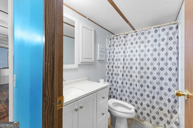 a bathroom with a toilet and a shower curtain