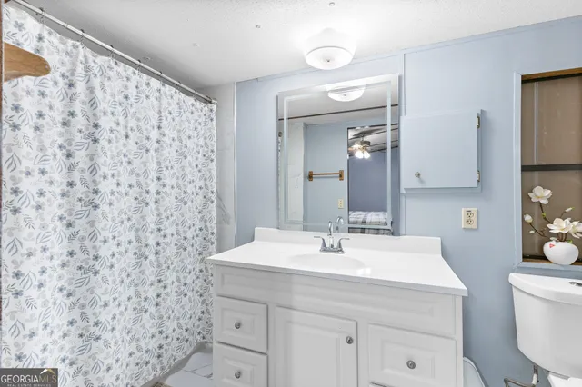 a bathroom with a sink a toilet and a mirror