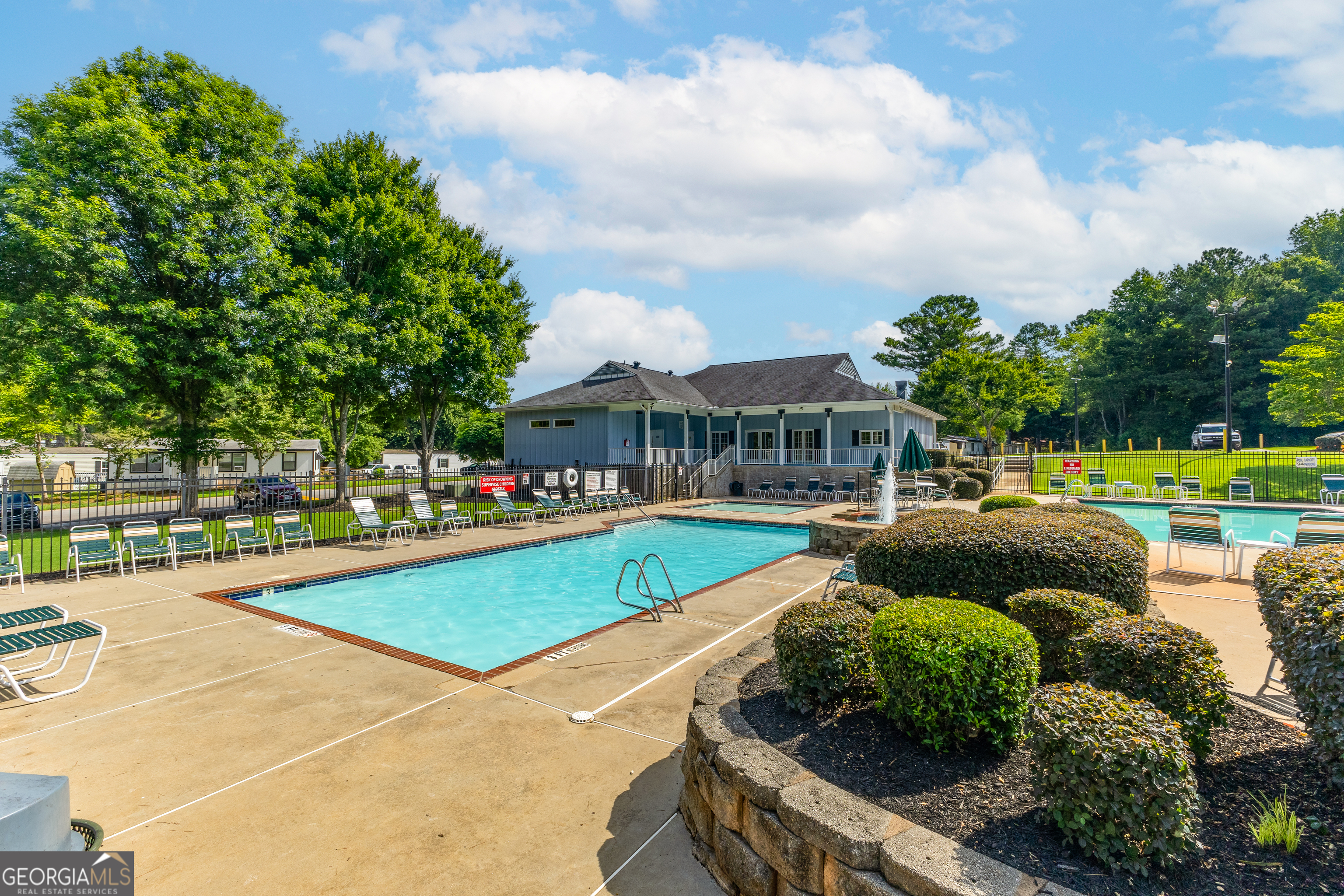 5758 Hickory Wood Lane, Unit 336 Buford, GA 30518 - Photo 28 of 28 a view of a swimming pool with lawn chairs and plants