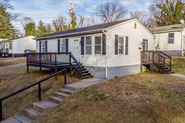 a view of a house with wooden deck and wooden fence