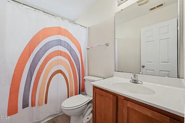 a bathroom with a double vanity sink mirror and toilet