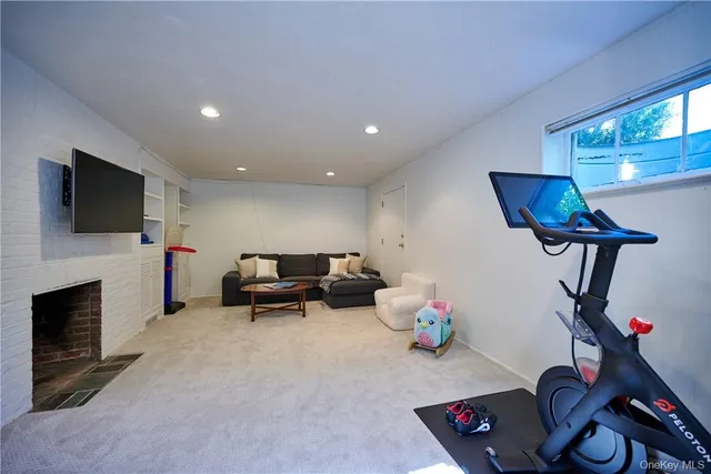 a living room with furniture a flat screen tv and a fireplace