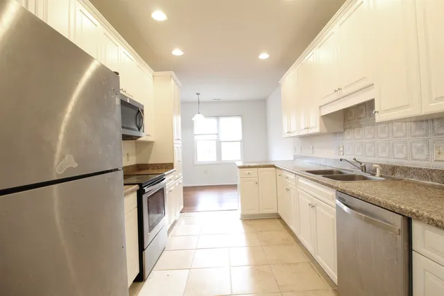 a kitchen with stainless steel appliances granite countertop a sink and a stove