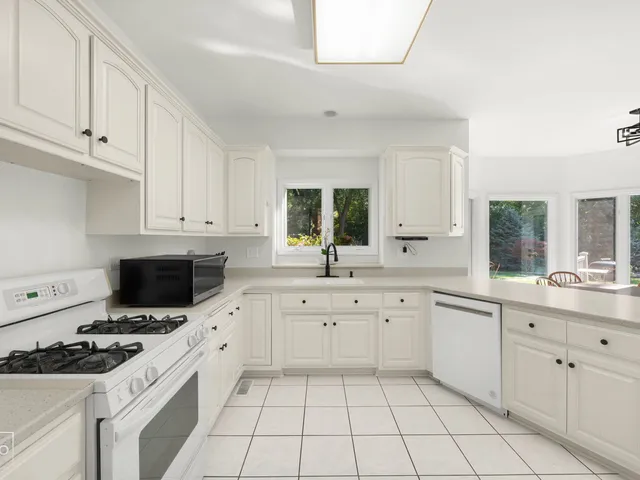 a kitchen with appliances a sink and cabinets