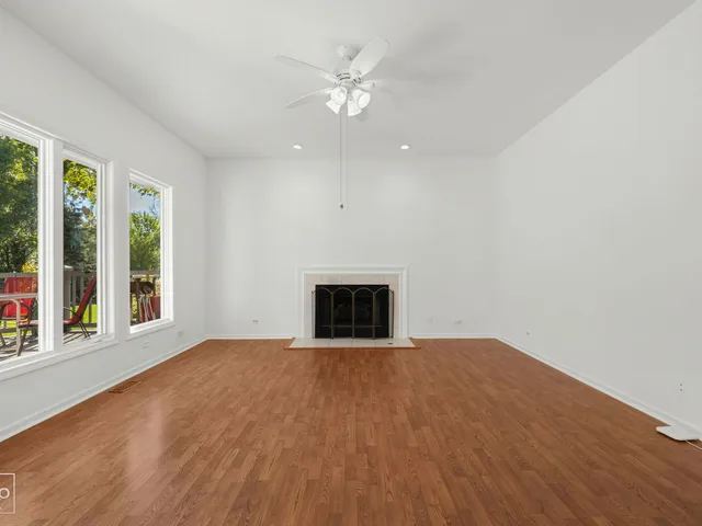 a view of an empty room with a fireplace and a window