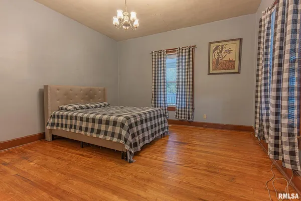 a bedroom with a bed and a chandelier