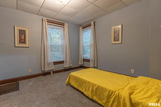 a bedroom with a bed and a painting on the wall