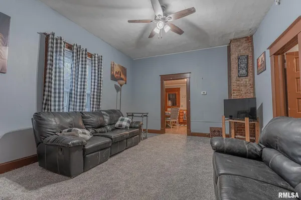 a living room with furniture and a ceiling fan