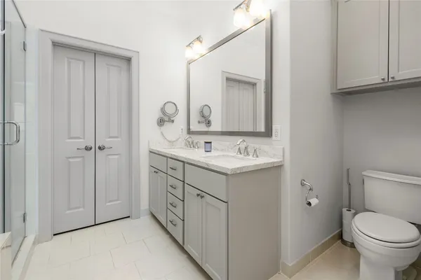 a bathroom with a granite countertop toilet sink and mirror