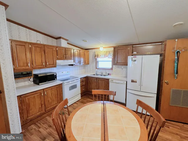 a kitchen with stainless steel appliances granite countertop a refrigerator a stove top oven a sink and dishwasher