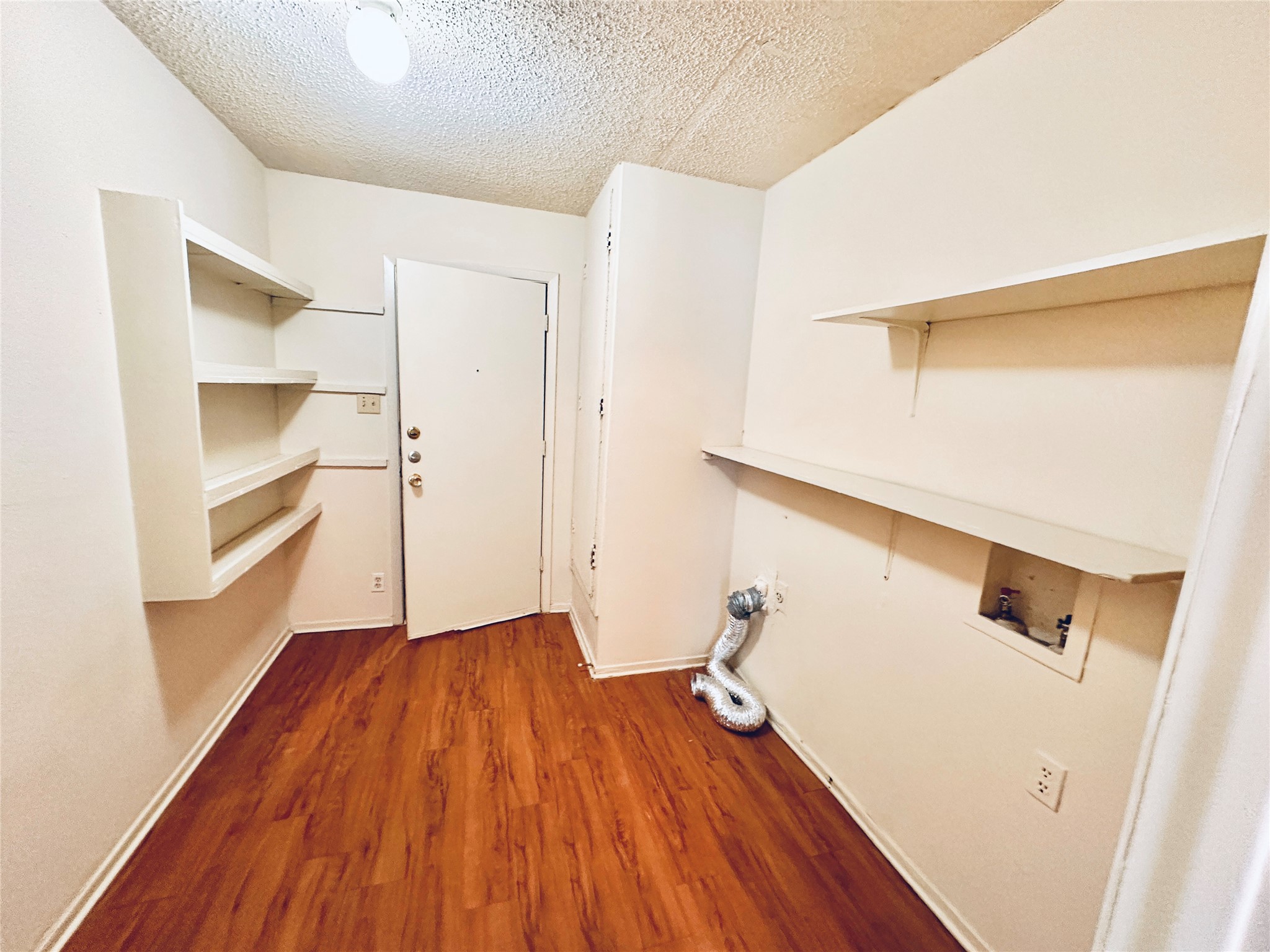 12504 Tree Line Drive, Unit B Austin, TX 78729 - Photo 10 of 22 Laundry room with dark wood-type flooring, a textured ceiling, and washer hookup