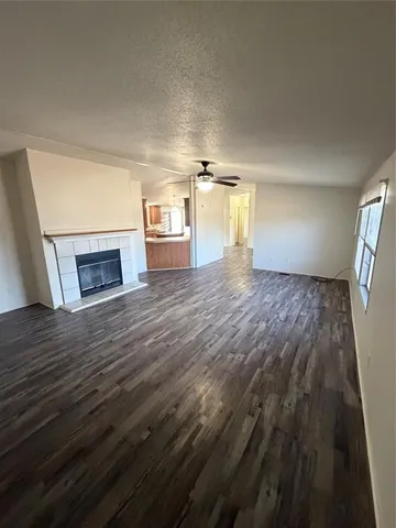 a view of empty room with wooden floor and fireplace
