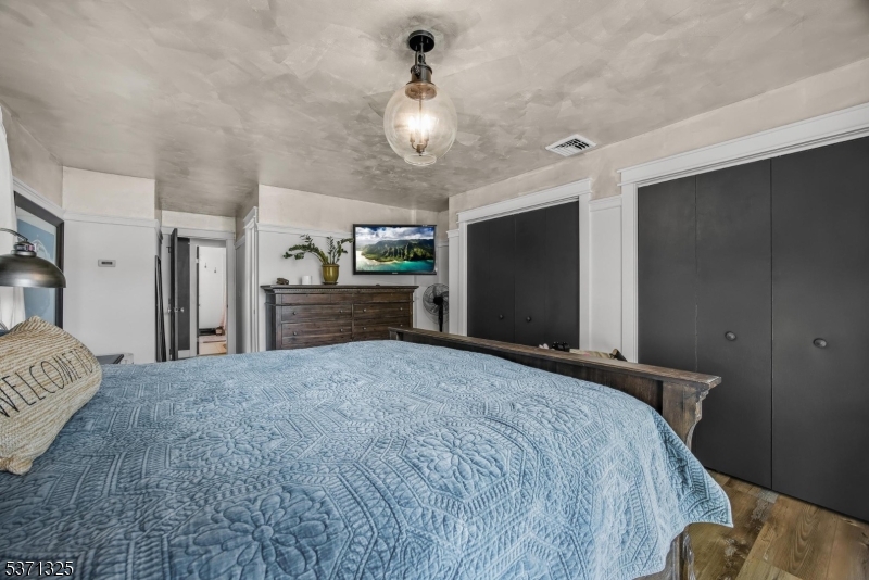 590 West Shore Trail Sparta, NJ 07871 - Photo 15 of 41 a spacious bedroom with a bed and a chandelier