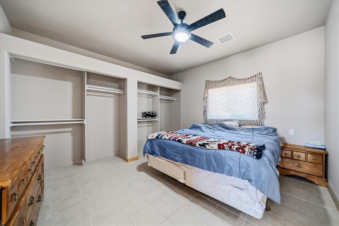 10374 East Happy Trails Road Kingman, AZ 86401 - Photo 27 of 68 a bedroom with a bed and a ceiling fan