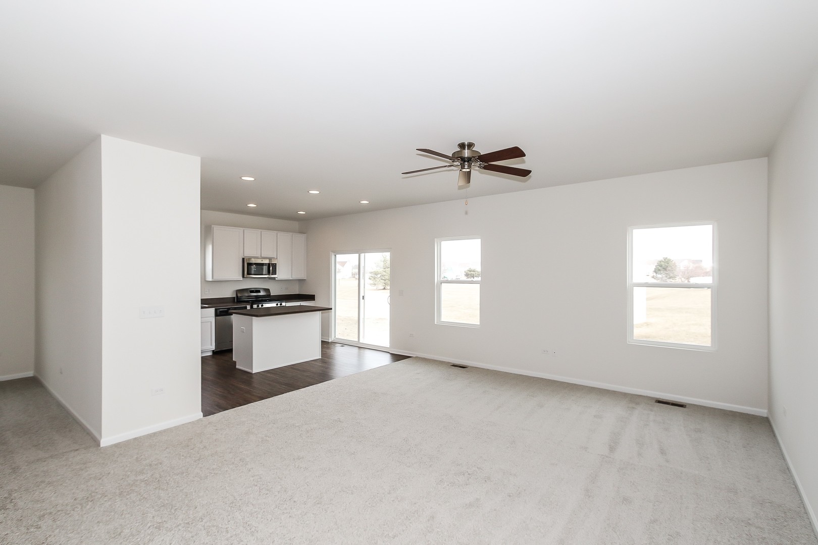 904 Sharp Drive, Unit 1593 Plano, IL 60545 - Photo 15 of 39 a living room with stainless steel appliances kitchen island furniture and a window