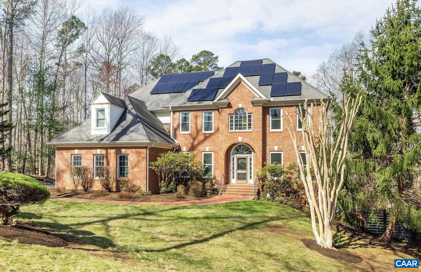 a front view of a house with a garden and trees