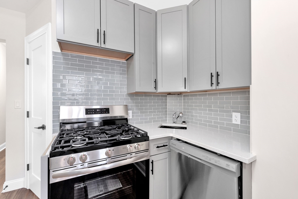 16 O Street, Unit 2 Boston, MA 02127 - Photo 14 of 19 a kitchen with a stove and white cabinets