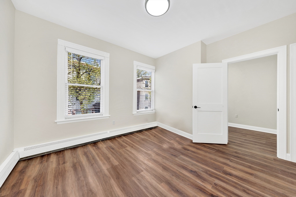 16 O Street, Unit 2 Boston, MA 02127 - Photo 16 of 19 an empty room with wooden floor and windows