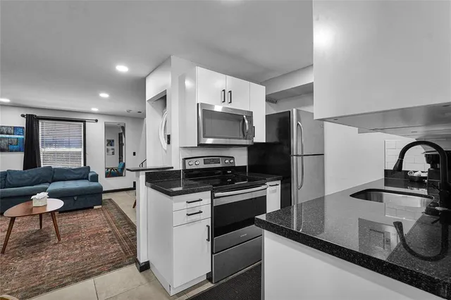 a backyard of a house with large trees and wooden fence