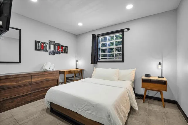 a bedroom with a large bed and a flat tv screen