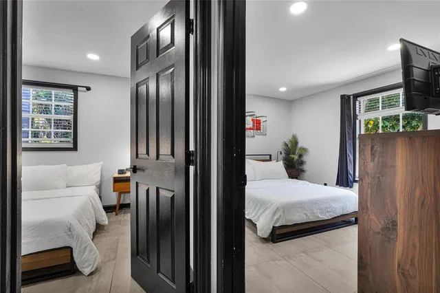 a bedroom with two beds and a flat screen tv