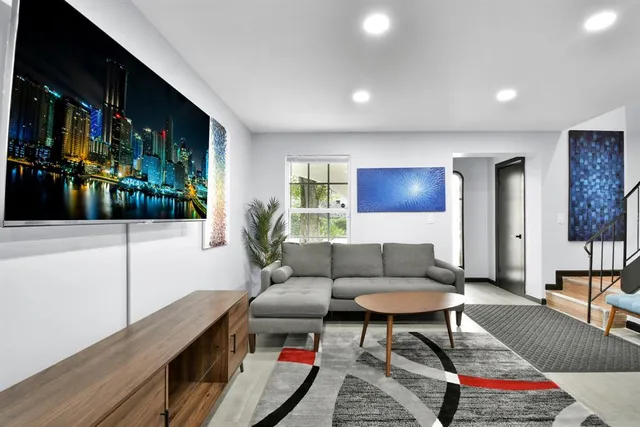 a living room with furniture a flat screen tv and a fireplace