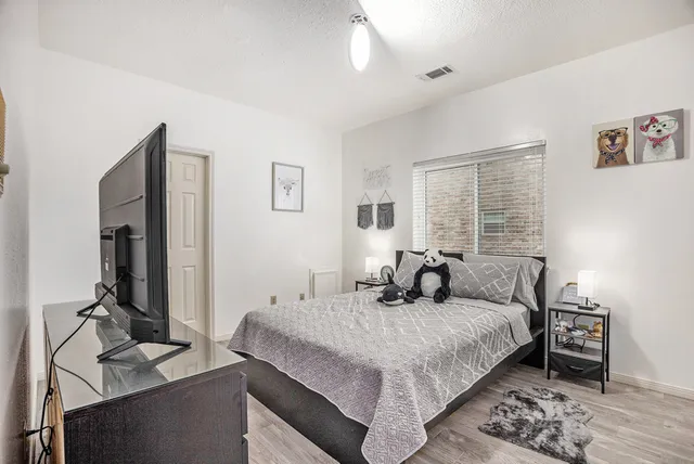 a bedroom with a bed and wooden floor