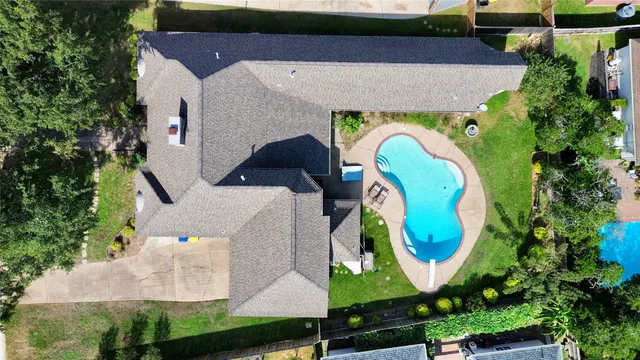 an aerial view of a house with swimming pool and outdoor seating