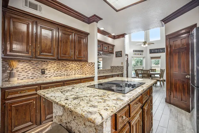 a kitchen with stainless steel appliances granite countertop a stove refrigerator and cabinets