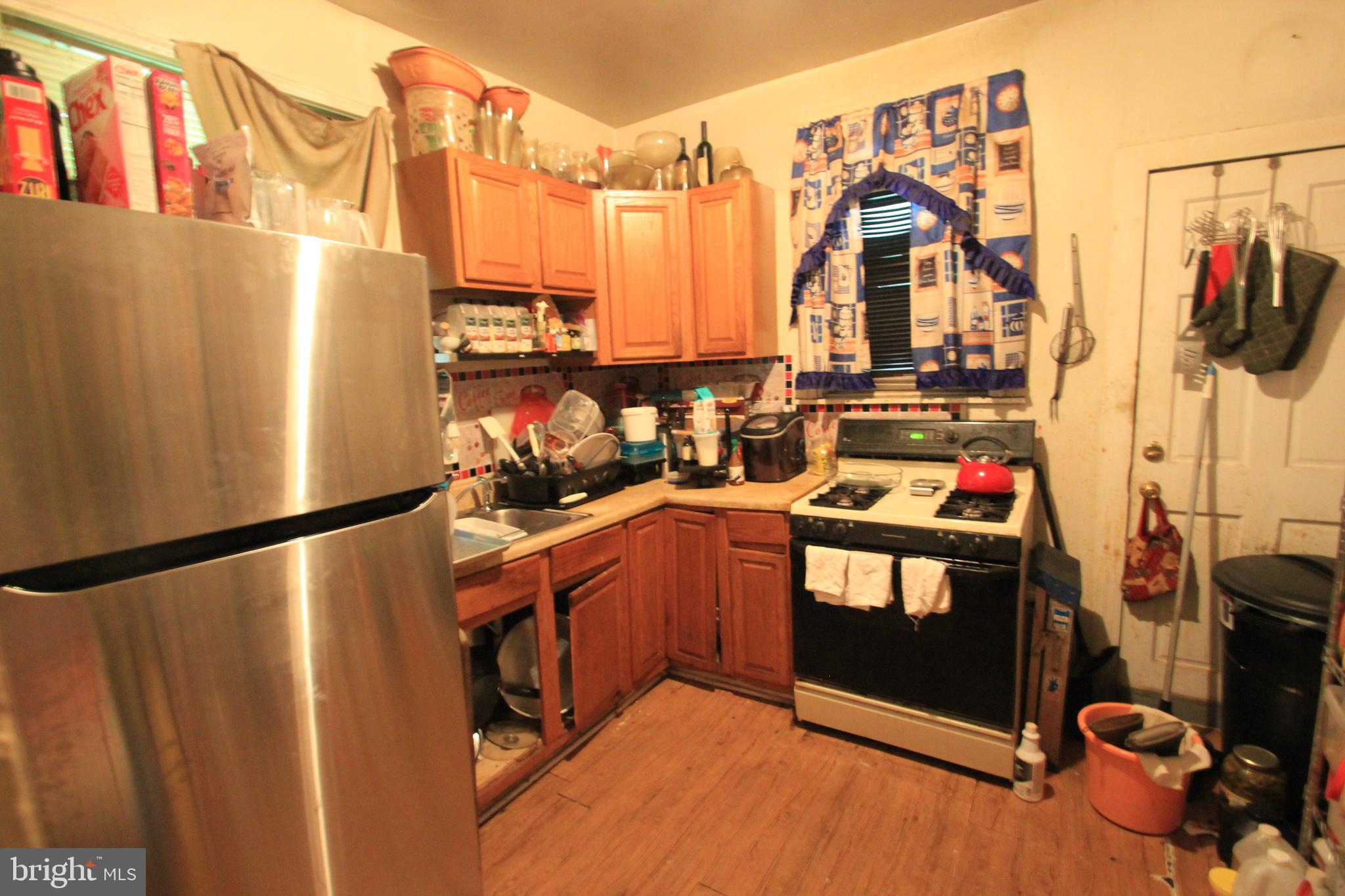 5747 Belmar Street Philadelphia, PA 19143 - Photo 4 of 13 a kitchen with stainless steel appliances a refrigerator and a wooden floor