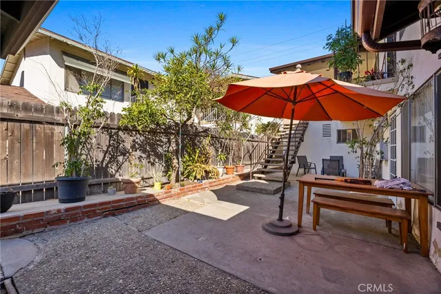 a view of the patio with a table and chairs under an umbrella