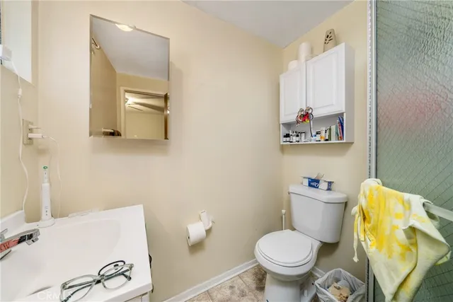 a white toilet sitting next to a bathroom sink and vanity