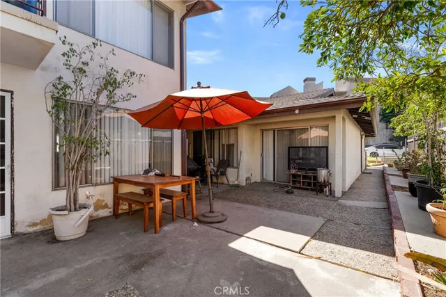 a view of a house with patio furniture and potted plants