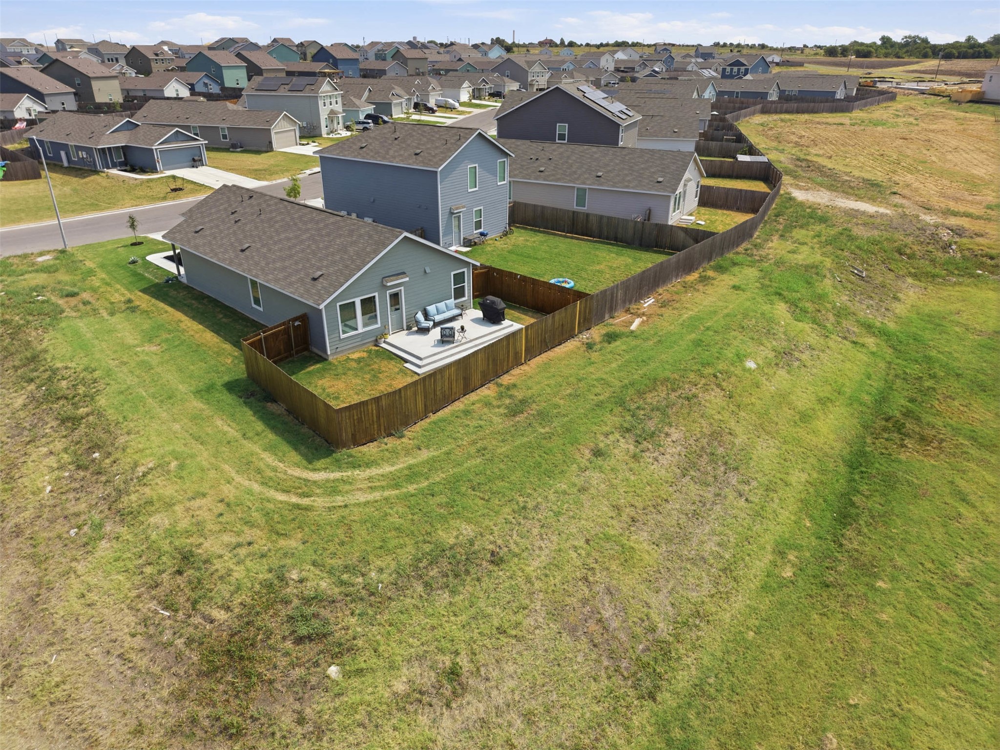 171 Cattle Queen Road Jarrell, TX 76537 - Photo 33 of 38 An aerial perspective showcases a fenced backyard with an elevated deck overlooking green space.