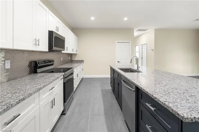 a large kitchen with stainless steel appliances granite countertop a lot of counter space