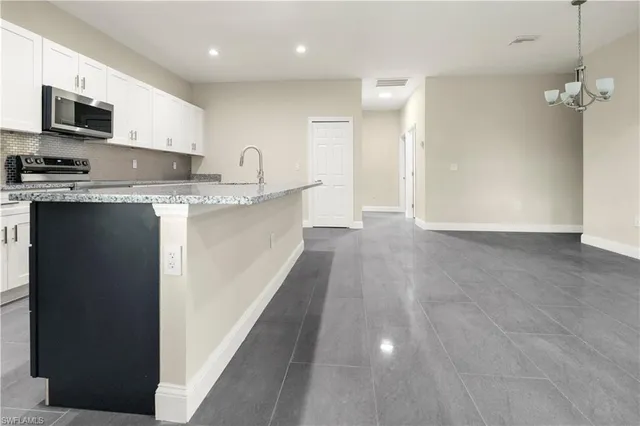 a large kitchen with stainless steel appliances granite countertop a stove a sink and a refrigerator