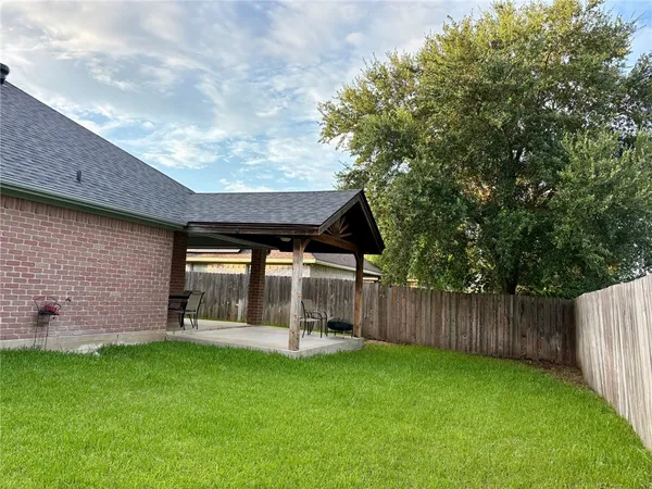 a backyard of a house with table and chairs