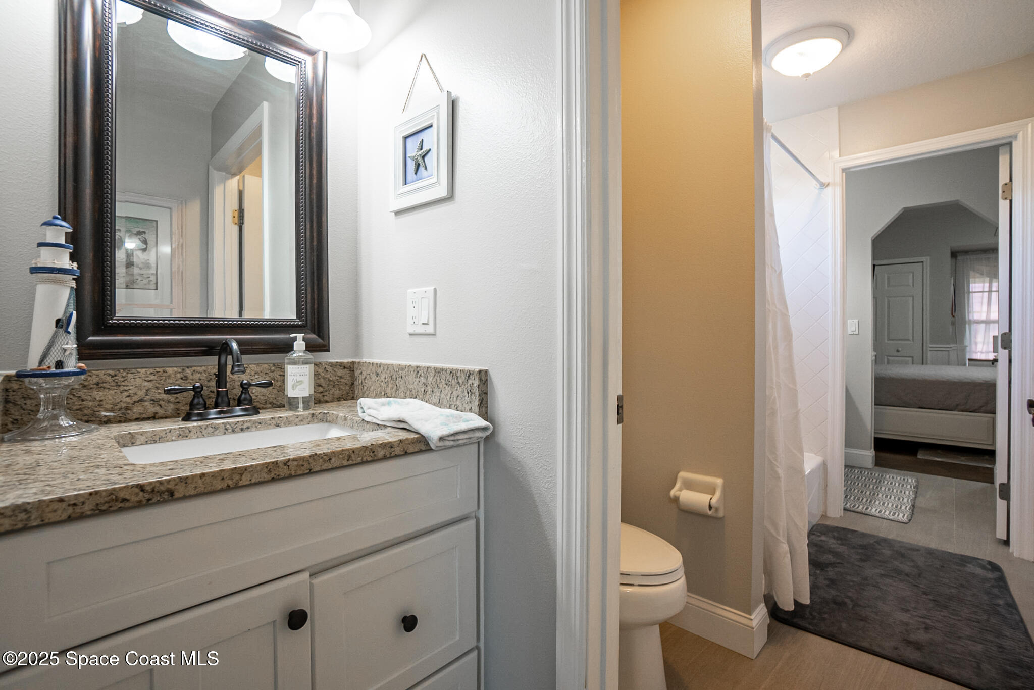 1868 Druliner Road St. Cloud, FL 34771 - Photo 34 of 57 a bathroom with a granite countertop toilet sink and mirror