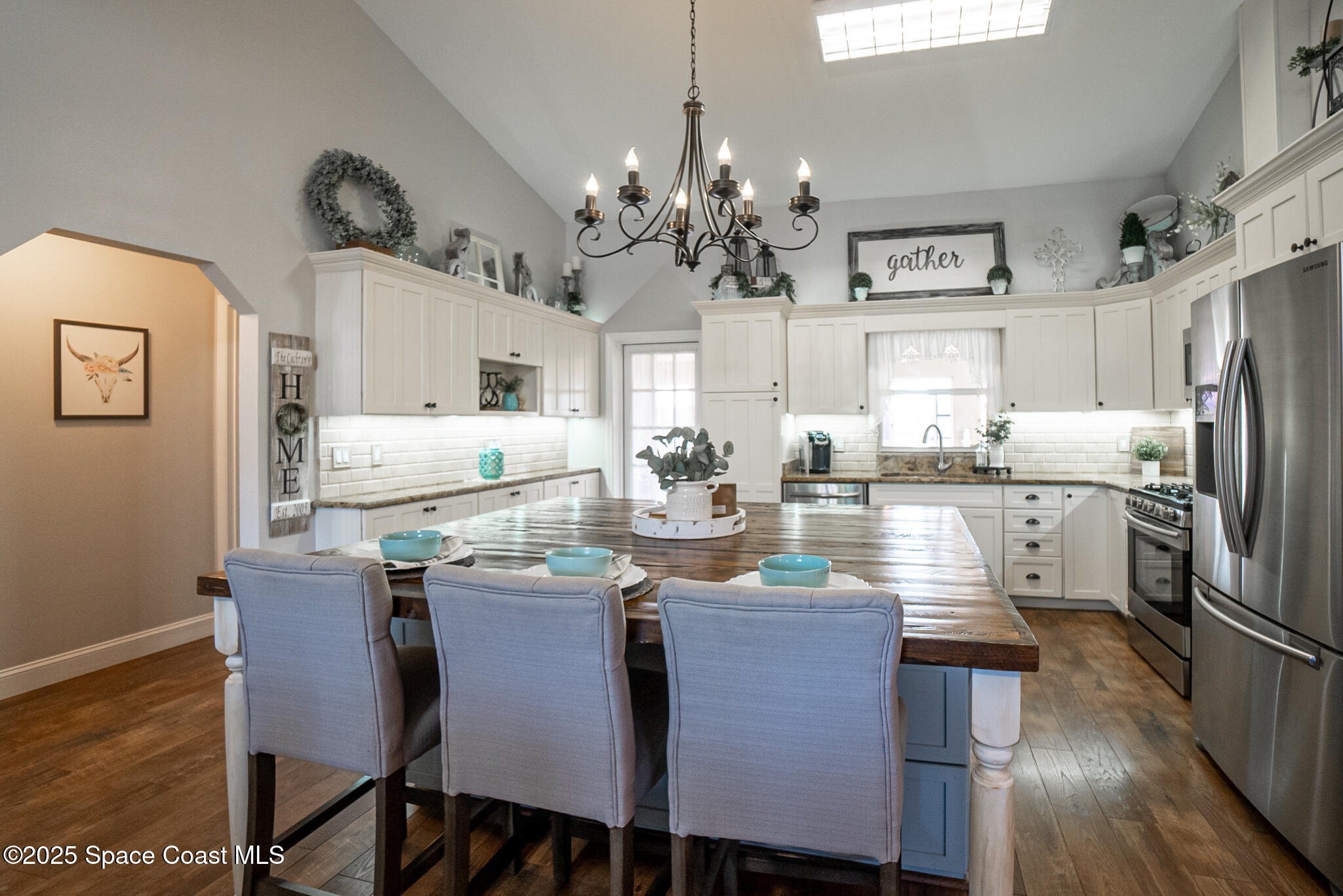1868 Druliner Road St. Cloud, FL 34771 - Photo 9 of 57 a dining room with stainless steel appliances kitchen island granite countertop a table chairs and a refrigerator